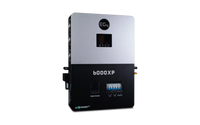 A rectangular BigBattery 6000XP power inverter with a display screen, labeled in black and silver in IBM Plex Sans font, features multiple ports and switches visible on the front panel.