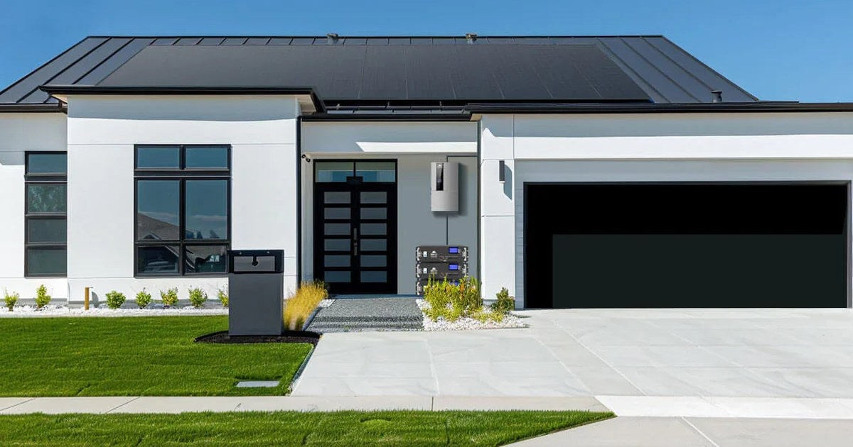 Modern home with a rooftop solar array, wall-mounted hybrid inverter and lithium batteries