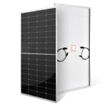 A rectangular Rich Solar panel stands upright with black photovoltaic cells under anti-reflective glass on the front, and a white back featuring electrical cables and a warning label.