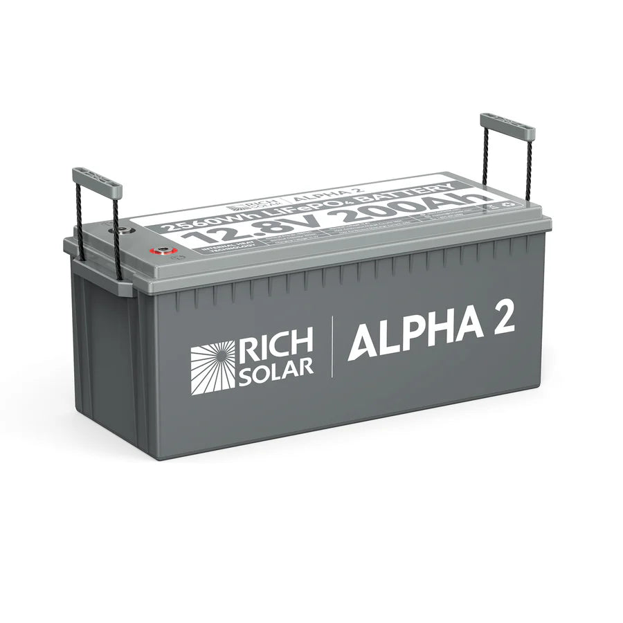 A rectangular gray Rich Solar LiFePO4 battery labeled ALPHA 2, 12.8V 200Ah, 2560Wh, with two lifting handles on each end.