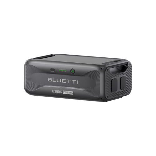 A rectangular, dark gray Bluetti portable power station labeled B300K 2764.8Wh features indicator lights, buttons, a handle, and modular design—offering an advanced energy solution against a white background.