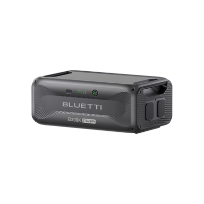A Bluetti B300K portable power station in black with a textured surface, LED indicators, various ports, side handle, and 2764.8Wh capacity. Compatible with AC500 for expanded solar storage.