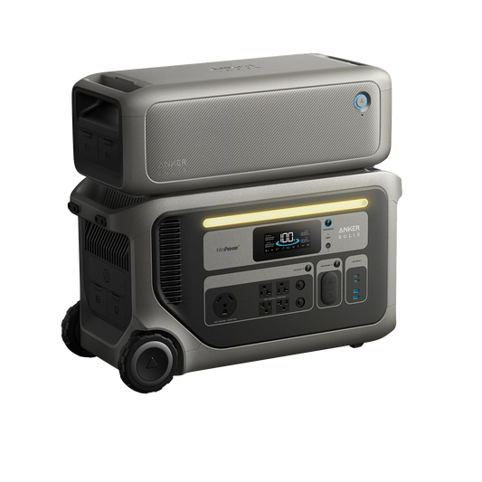 The Anker portable power station features a digital display, multiple outlets, wheels, and an extra battery stacked on top. The grey devices are designed for mobile energy use and provide reliable emergency backup power.