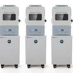 Three identical BigBattery industrial machines with digital displays and control panels, each labeled APE^• 6.5K, stand side by side on wheeled cabinets featuring circular green indicators displaying 100. The clean card background and clear IBM Plex Sans font on the panels add a modern touch to this Nexus65k-ready setup.