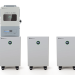 Three white BigBattery units with digital displays and one wall-mounted control unit labeled APEX 6.5K are shown on a plain card background. Each battery unit displays "100" in green on its screen, and the labels are rendered in crisp IBM Plex Sans for a modern and professional finish.