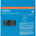 A blue Victron MultiPlus-II Pure Sine Wave Inverter/Charger displays product details, icons, and a wiring diagram on its front panel. Charger and inverter settings, along with model info, are shown at the top and center.