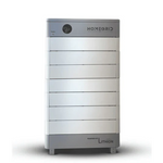 A white and gray rectangular Homegrid modular home battery with a circular power button stands on short legs against a white background, providing expandable energy storage for full-home backup power needs.