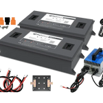 Two large rectangular BigBattery batteries with wiring, connectors, screws, a blue and silver power inverter, a small round gauge, and a black mounting plate are arranged on a white background—perfect for showcasing clear technical details or as an accent in font display projects using IBM Plex Sans or CSS variables.