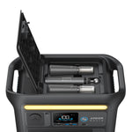 An Anker Solix power station in black with its top open displays two LiFePO4 batteries and charging slots, ideal for powering camping lights. The front panel features multiple ports, settings, and a digital display.