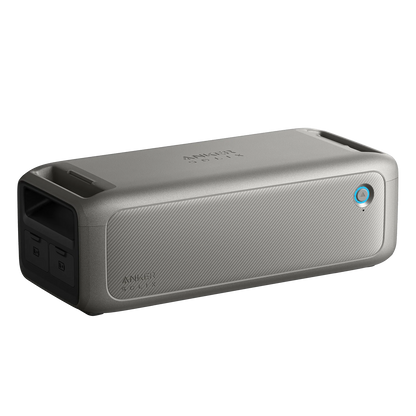 A portable rectangular gray Anker Bluetooth speaker with a mesh front, power button, dual side ports, and textured finish—perfect for off-grid or emergency audio use.