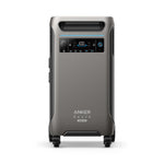 A metallic gray Anker portable power station features a digital display, control buttons, top handle, base wheels, plus front-panel power indicators, multiple connection ports, and solar input for convenient backup power.