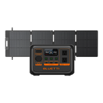 A Bluetti portable power station with a LiFePO4 battery, control panel, and outlets stands before four foldable solar panels connected together.