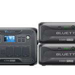 A Bluetti AC500 portable power station, paired with two B300K battery modules in sleek black and featuring digital displays, is ideal for on-the-go solar energy use.