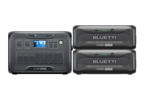 A Bluetti AC500 portable power station, paired with two B300K battery modules in sleek black and featuring digital displays, is ideal for on-the-go solar energy use.