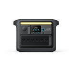 The black Anker SOLIX Portable Power Station features multiple outlets, USB ports, a digital display, and a yellow handle for reliable backup power and solar charging for your devices, displayed on a white background.