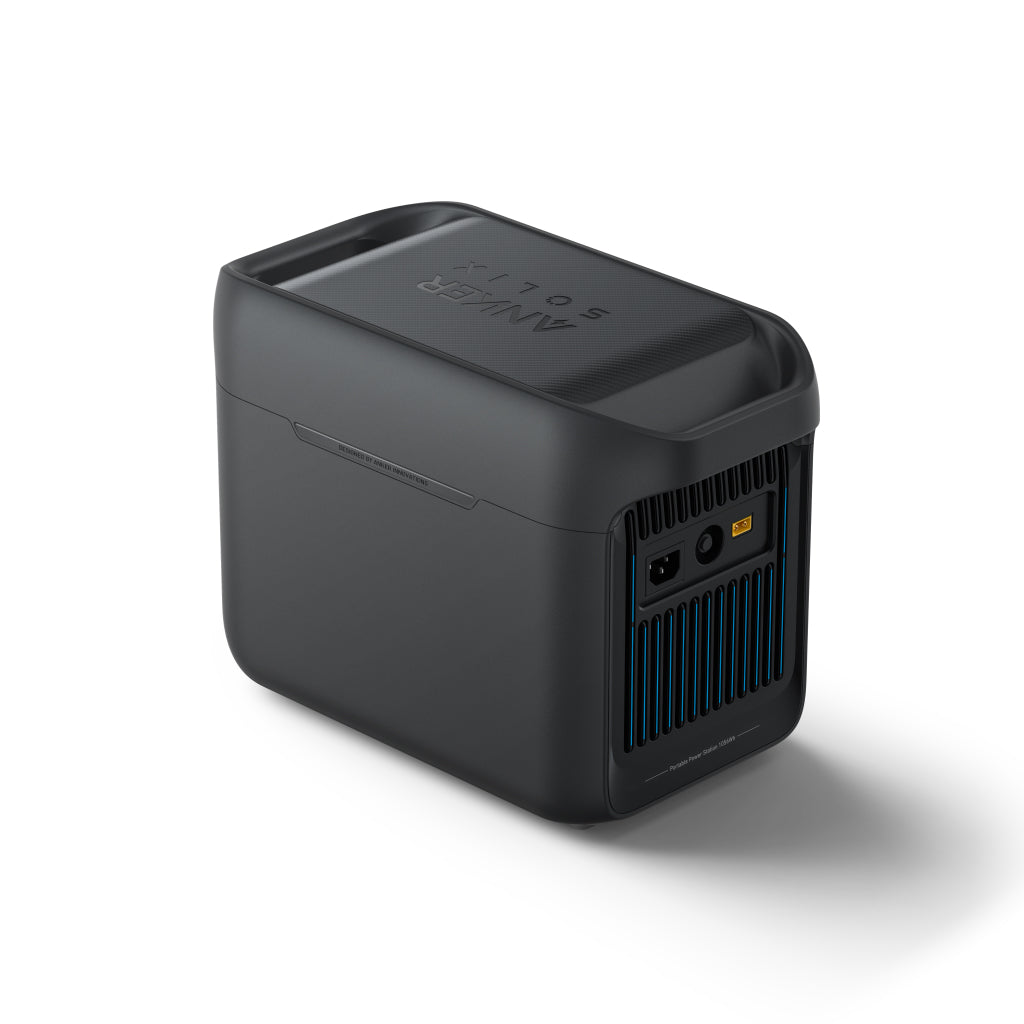 An Anker SOLIX Portable Power Station in black, featuring a textured lid, rear vent, and multiple power ports, is displayed on a white background. It supports solar charging for enhanced convenience.