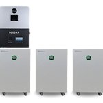 A wall-mounted BigBattery 6000XP power unit is situated above three white BigBattery battery units featuring digital displays, all arranged side by side against a plain white background. Their sleek design is accentuated by smooth border radius edges and modern aesthetics reminiscent of the IBM Plex Sans font family.