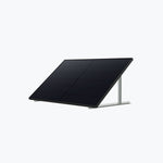 An Anker black solar panel is mounted on a metal frame, angled upward for optimal sunlight, set against a plain light gray background.