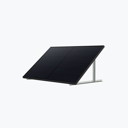An Anker black solar panel is mounted on a metal frame, angled upward for optimal sunlight, set against a plain light gray background.