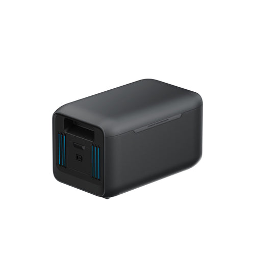 A black, rectangular Anker SOLIX BP1000X Expansion Battery with rounded edges, a USB port, and blue vent lines on one end is displayed against a plain white background.